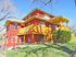 Inviting two-story brick home with warm wooden accents and a sunny porch.