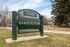 Barnum Park entrance sign in Denver, surrounded by grass and trees.
