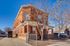 Elegant red-brick apartment building with charming architectural details on a sunny day.