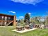 Inviting outdoor space with picnic benches and a play area set against a bright blue sky.