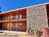 Charming two-story brick apartment building with a modern stone accent wall and inviting double-door entry, basking in bright sunlight.