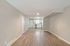 Contemporary open-concept living space with sleek hardwood floors leading to a modern kitchen, ideal for urban living.