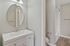Elegant bathroom featuring a sleek vanity with a modern mirror, and a stylish shower-tub combination.