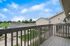 Inviting apartment balcony with wooden railing offering scenic neighborhood views and a bright blue sky.