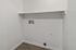 Modern utility space with stylish wood flooring and clean, white walls, ready for customization.