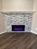 Chic modern fireplace with sleek stone surround and warm wood flooring, perfect for cozy ambiance and contemporary living.