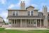 Charming townhouse with a classic facade, featuring spacious balconies and a cozy front porch, perfect for modern living.
