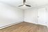 Bright and airy room with sleek wood floors and a modern ceiling fan, perfect for a cozy bedroom retreat.