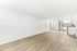 Bright, open-concept living and kitchen area featuring sleek stainless steel appliances, modern cabinetry, and stylish wood flooring.