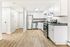 Chic modern kitchen with sleek stainless steel appliances, elegant white cabinetry, and warm wood flooring.