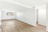 Bright and spacious living area with elegant hardwood flooring and large window offering ample natural light.