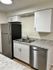 Modern kitchen with elegant granite countertops, sleek stainless steel fridge, and dishwasher for a stylish living experience.