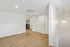 Modern open hallway with sleek wooden flooring and stylish lighting, leading to a versatile laundry area with ample storage space.