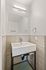 Modern bathroom with sleek basin sink, elegant wall-mounted mirror, and stylish tile design, perfect for a contemporary home.