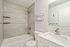 Modern bathroom with sleek white fixtures, elegant tile work, and a stylish vanity for a touch of luxury.