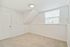 Bright, cozy room with fresh carpet and a large window offering plenty of natural light.