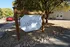 Inviting entrance to Sherlock Townhomes with a rustic wooden sign framed by lush trees and natural stone landscaping.