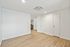 Bright, modern room with sleek wooden flooring, white walls, and recessed lighting, ideal for versatile living space.