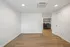 Bright modern room with elegant wood flooring and recessed lighting, leading to a convenient in-unit laundry area with built-in shelving.