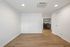 Inviting space with sleek wooden flooring and modern lighting, leading to a well-equipped laundry area.