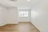 Bright and inviting empty room with elegant wooden flooring, large window, and modern white walls.