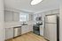 Modern kitchen with sleek stainless steel appliances, elegant cabinetry, and natural light highlighting the beautiful hardwood flooring.