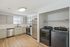 Modern kitchen with sleek cabinetry, stainless steel appliances, and built-in laundry area, showcasing a bright, open space with hardwood floors.