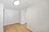 Bright and modern room with elegant wooden flooring and sleek white walls, perfect for versatile styling.
