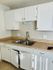 Bright, modern kitchen with sleek white cabinets and a double stainless steel sink, ideal for culinary creativity.