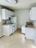 Charming and efficient kitchen with white cabinetry, modern appliances, and ample countertop space.