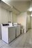 Modern laundry area featuring a sleek washer and dryer set in a bright, tiled utility room.