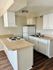 Bright and cozy kitchen with modern appliances, ample counter space, and sleek wooden flooring.