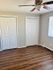 Charming bedroom featuring elegant hardwood floors, dual closets, and a ceiling fan for comfort.