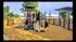 Charming playground with vibrant play structure, surrounded by a wooden fence and lush greenery, perfect for family fun.