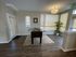 Bright apartment corner with elegant laminate flooring, featuring a foosball table and stylish decor accentuated by natural light and a potted plant.