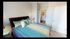 Inviting bedroom with modern decor, featuring a plush bed with teal accents and a glimpse into an adjoining bathroom.