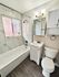 Modern bathroom with elegant marble tiles, stylish fixtures, and a pristine bathtub for a luxurious feel.