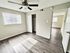 Bright and airy bedroom with sleek hardwood floors and natural light, featuring a ceiling fan and spacious closet.