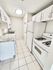 Bright and modern kitchen featuring sleek white cabinets, granite countertops, and a cozy layout perfect for culinary creativity.