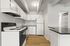 Modern kitchen featuring sleek cabinets, stainless steel appliances, and elegant wood flooring.