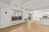 Bright open-plan living space with modern kitchen and large windows offering a scenic view, perfect for urban living.