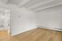 Bright and airy room with beautiful wood flooring, featuring modern minimalist design and exposed ceiling beams.