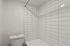 Modern bathroom with elegant white subway tiles and a pristine white bathtub, offering a clean and inviting atmosphere.