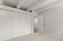 Bright and airy bedroom featuring a spacious closet with sleek white doors and plush carpeting, exuding modern elegance.
