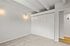 Bright room with soft carpet, modern overhead beams, and sleek built-in closet for stylish living.