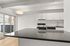 Elegant modern kitchen with sleek black countertops, white cabinetry, and a stylish backsplash, featuring large windows opening to a bright view.