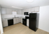 Modern kitchen with sleek black appliances, elegant grey cabinets, and stylish marble countertops.