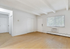 Bright, spacious living room with hardwood floors, large window, and air conditioning, offering a cozy and inviting atmosphere.