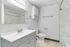 Modern bathroom with sleek vanity, elegant tile flooring, and marble accent walls.