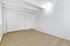 Bright and inviting bedroom with large closet, featuring elegant wood flooring and modern white walls.